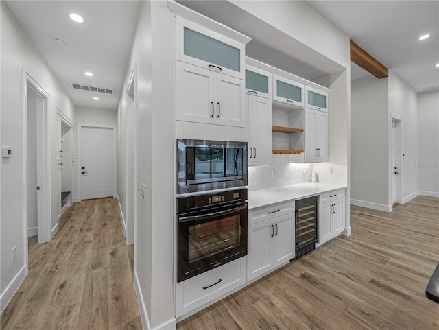 2728 Sunrise Landing Ln, Lakeland, FL 33812 - kitchen with oven, stainless steel microwave, wine cooler, light wood finished floors, and open shelves