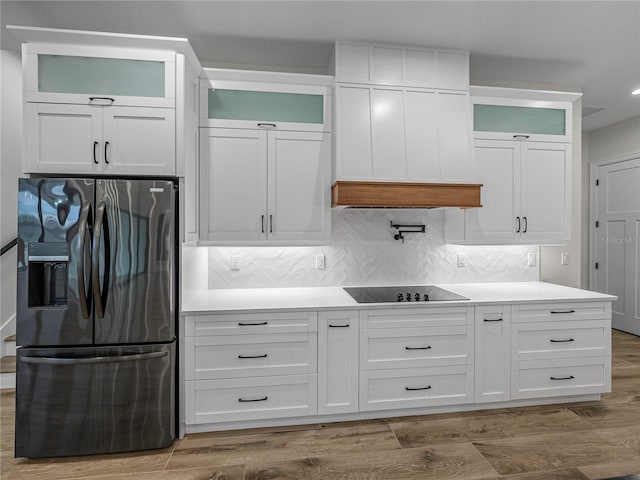 2728 Sunrise Landing Ln, Lakeland, FL 33812 - kitchen with refrigerator with ice dispenser, black electric stovetop, white cabinetry, and tasteful backsplash