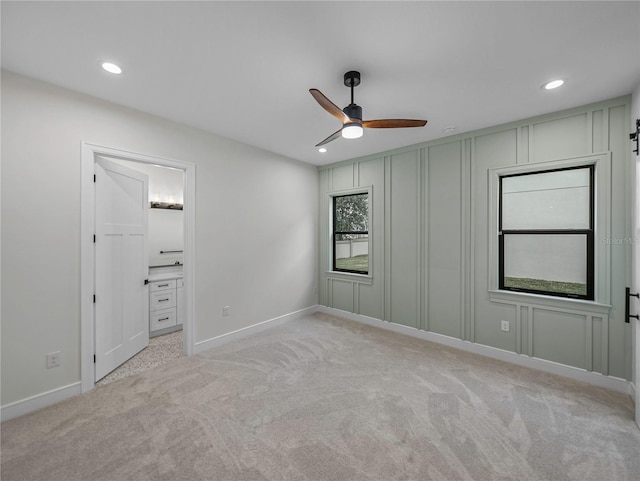 2728 Sunrise Landing Ln, Lakeland, FL 33812 - unfurnished bedroom with recessed lighting, baseboards, light colored carpet, a decorative wall, and ensuite bath