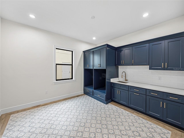 2728 Sunrise Landing Ln, Lakeland, FL 33812 - kitchen featuring a sink, decorative backsplash, light countertops, baseboards, and recessed lighting