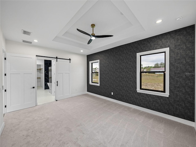 2728 Sunrise Landing Ln, Lakeland, FL 33812 - unfurnished bedroom featuring carpet, a barn door, a raised ceiling, recessed lighting, and a ceiling fan