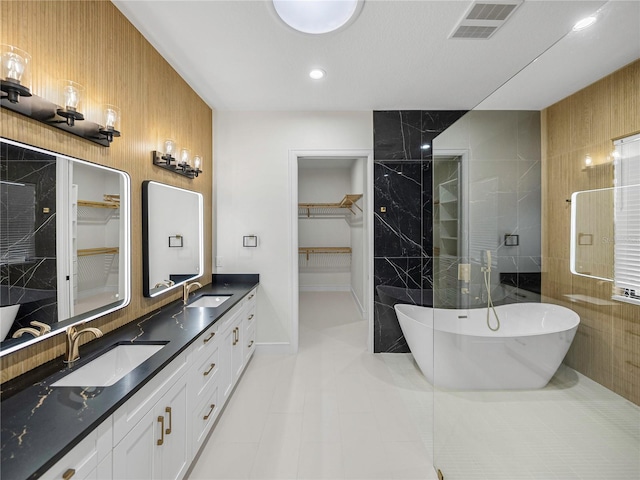 2728 Sunrise Landing Ln, Lakeland, FL 33812 - bathroom with a walk in closet, double vanity, a freestanding tub, tile patterned flooring, and recessed lighting
