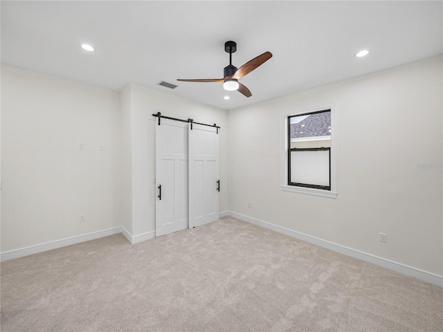 2728 Sunrise Landing Ln, Lakeland, FL 33812 - unfurnished bedroom with a barn door, recessed lighting, baseboards, light carpet, and a closet