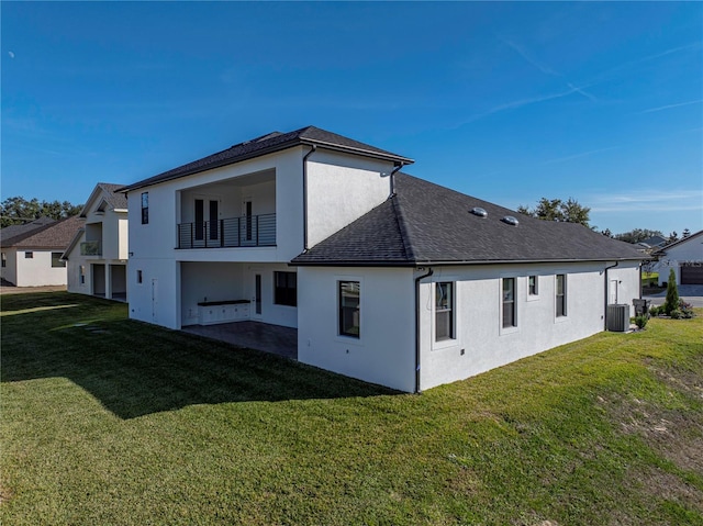 2728 Sunrise Landing Ln, Lakeland, FL 33812 - back of house with a balcony, stucco siding, a yard, and roof with shingles