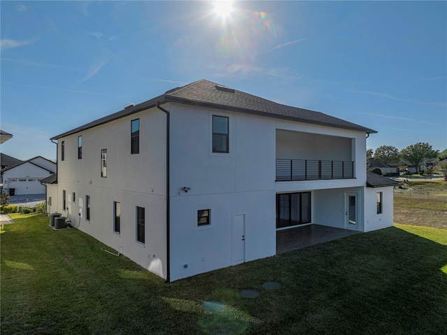 exterior space with a lawn, a balcony, cooling unit, and a patio