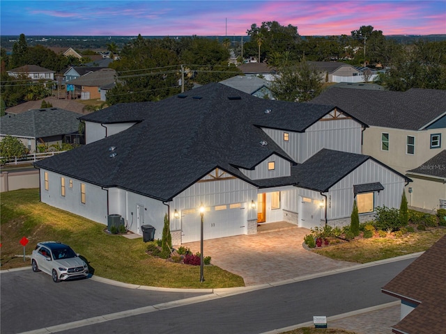 2728 Sunrise Landing Ln, Lakeland, FL 33812 - view of front of house featuring board and batten siding, a shingled roof, driveway, a garage, and a front lawn