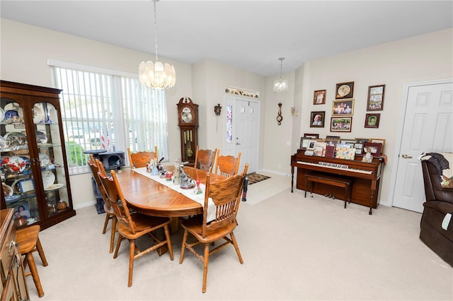 dining area featuring light carpet and a chandelier