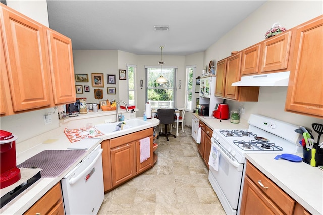 kitchen with decorative light fixtures, white appliances, and sink