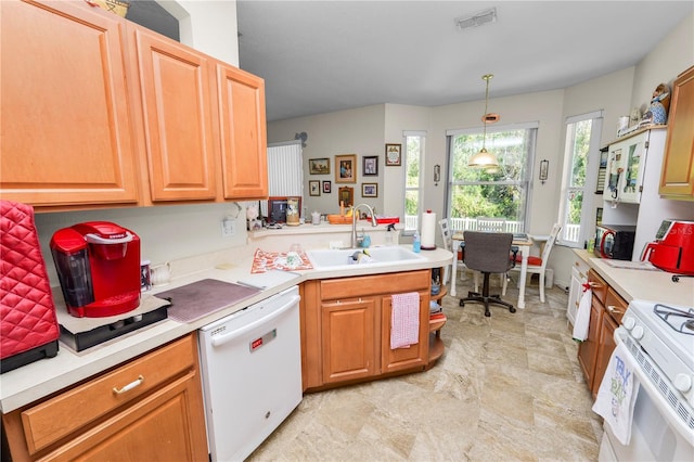 kitchen with pendant lighting, white appliances, and sink