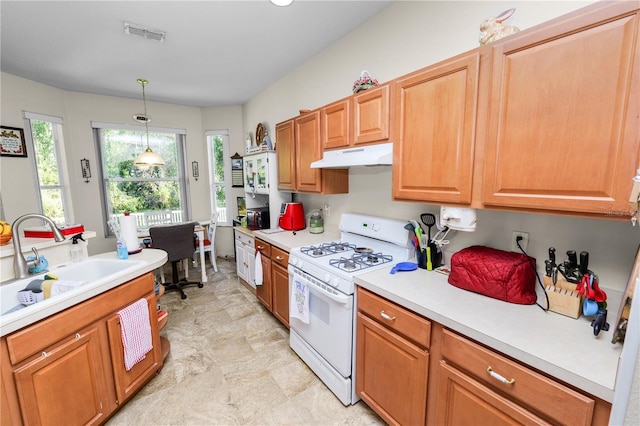 kitchen featuring decorative light fixtures, white gas stove, and sink