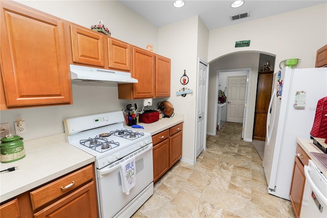 kitchen with washer and clothes dryer and white appliances