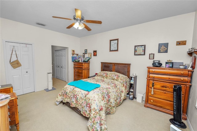 carpeted bedroom with ceiling fan and multiple closets