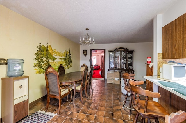 dining space with a chandelier and a textured ceiling