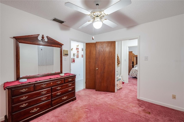 bedroom featuring a textured ceiling, light colored carpet, and ceiling fan