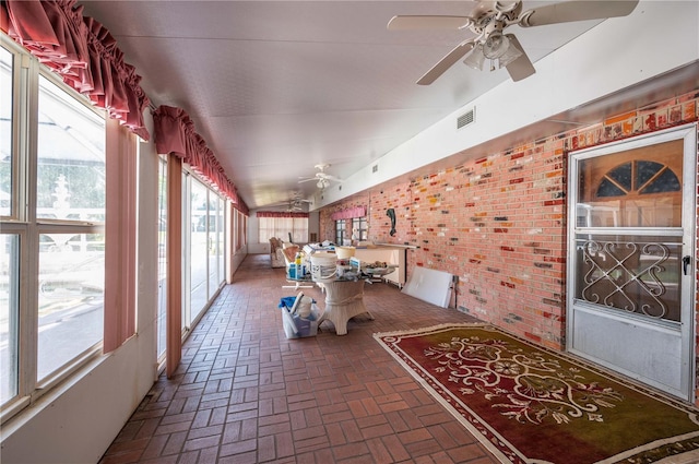 sunroom with ceiling fan and vaulted ceiling