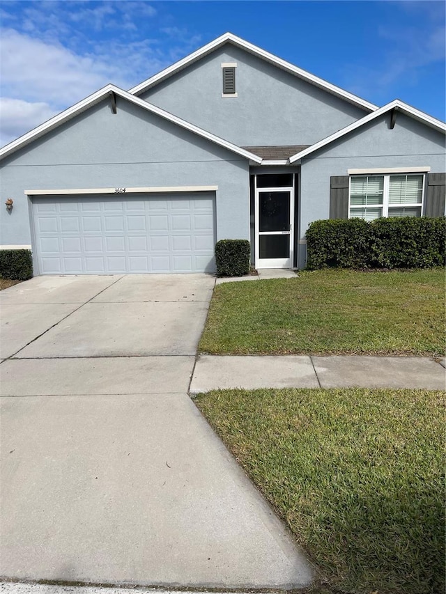 ranch-style home with a garage and a front lawn