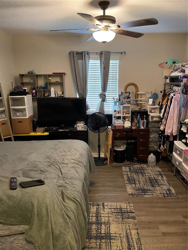 bedroom featuring hardwood / wood-style floors, ceiling fan, and a textured ceiling