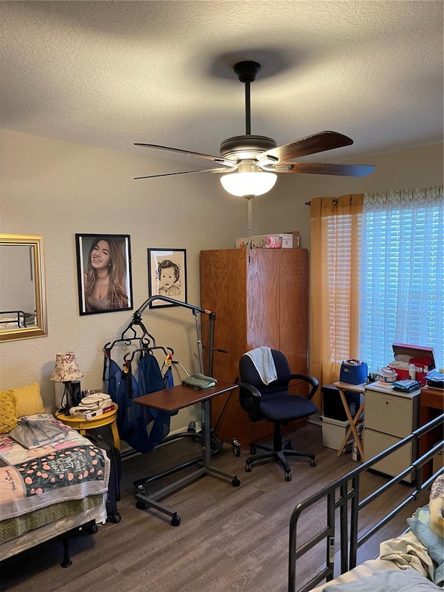 bedroom with ceiling fan, a textured ceiling, and hardwood / wood-style flooring