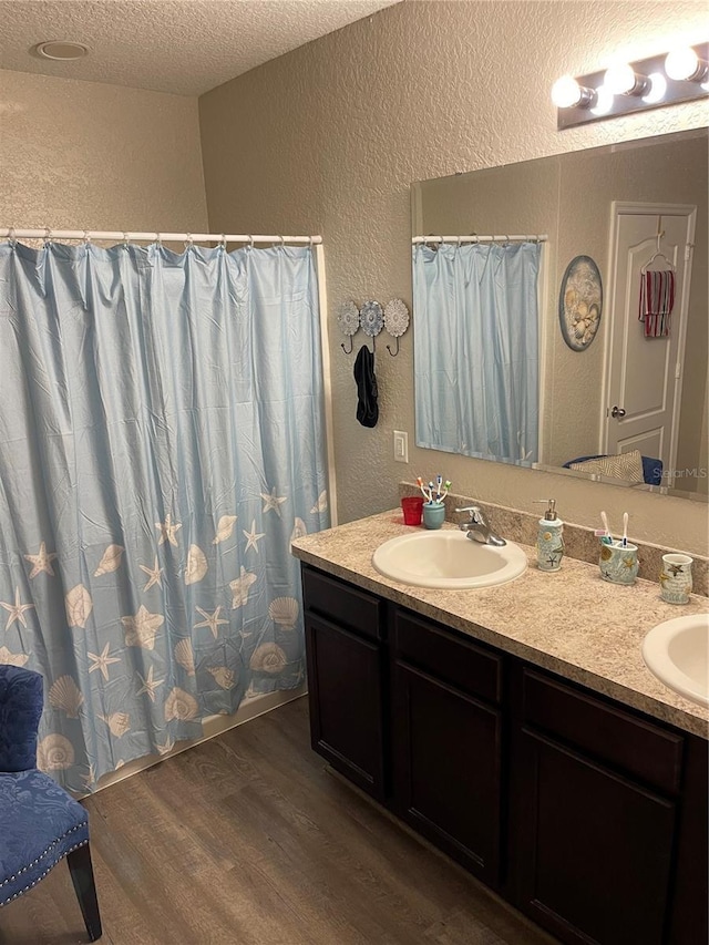 bathroom with vanity, a textured ceiling, and hardwood / wood-style flooring