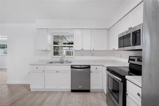 kitchen with white cabinets, appliances with stainless steel finishes, and sink