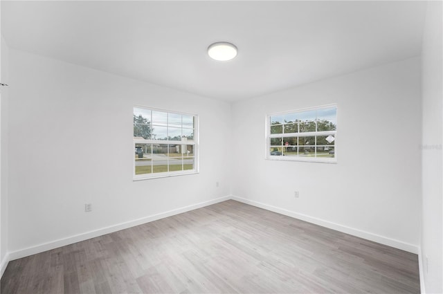 unfurnished room with plenty of natural light and hardwood / wood-style floors