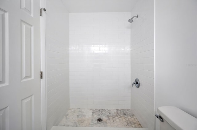 bathroom with toilet and a tile shower