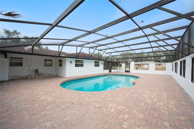 view of pool featuring glass enclosure and a patio area