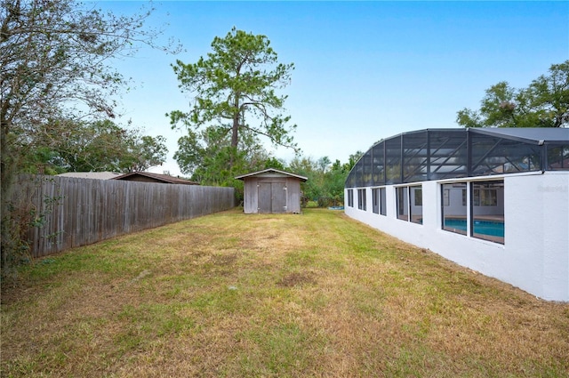 view of yard with a fenced in pool, a lanai, and a storage shed