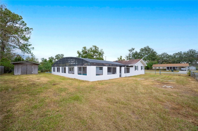 back of property with a storage unit and a yard