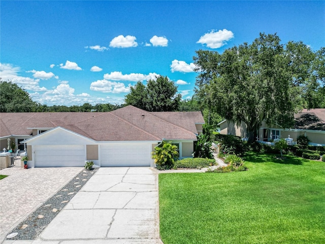 single story home featuring a garage and a front lawn