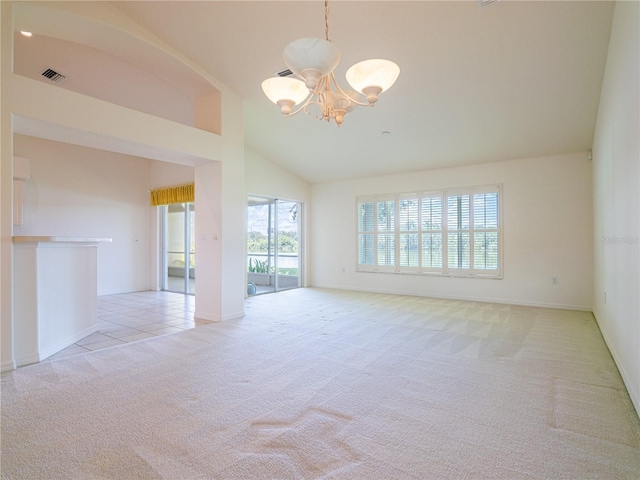 carpeted spare room with an inviting chandelier and high vaulted ceiling