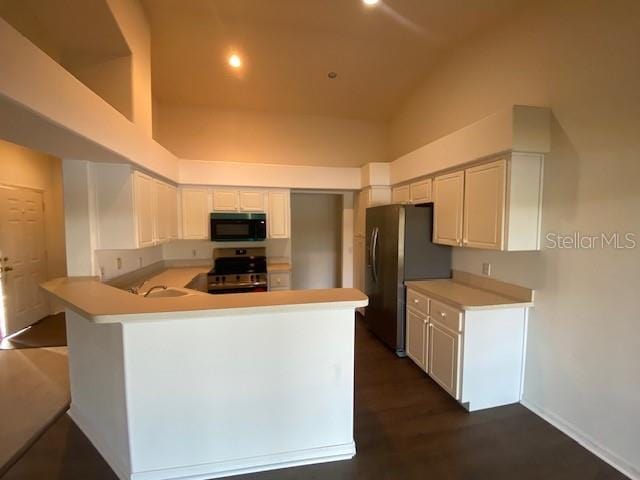 kitchen featuring white cabinetry, sink, dark hardwood / wood-style floors, kitchen peninsula, and appliances with stainless steel finishes