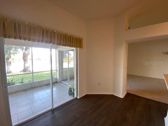 unfurnished room featuring dark hardwood / wood-style flooring and a healthy amount of sunlight