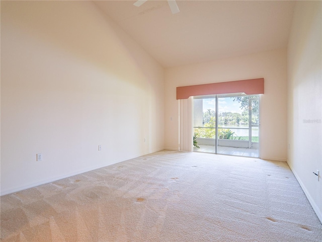 empty room featuring light carpet and high vaulted ceiling