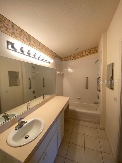 bathroom featuring tile patterned floors, vanity, a textured ceiling, and bathing tub / shower combination