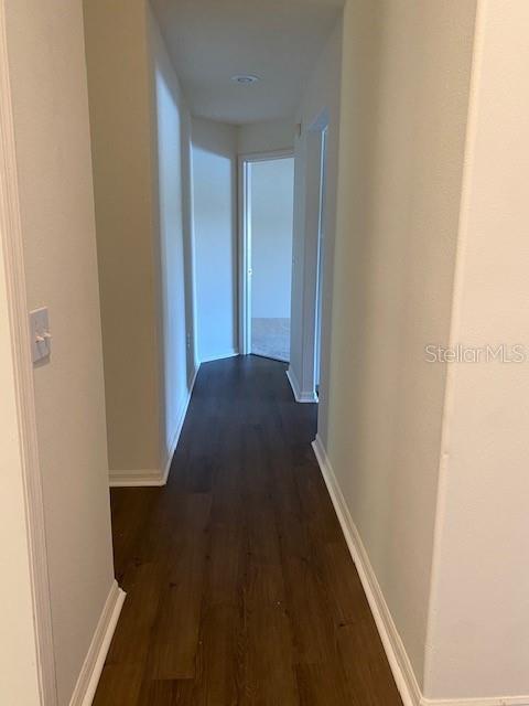 hallway with dark hardwood / wood-style floors