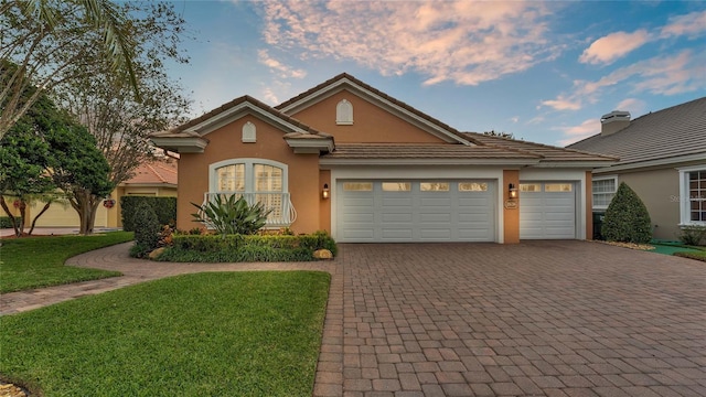 view of front of property with a garage and a lawn