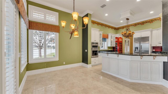 kitchen with stainless steel appliances, decorative light fixtures, a chandelier, and white cabinets