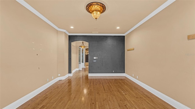 spare room featuring crown molding and hardwood / wood-style floors