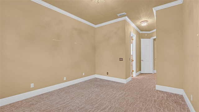 empty room with light colored carpet, ornamental molding, and a textured ceiling