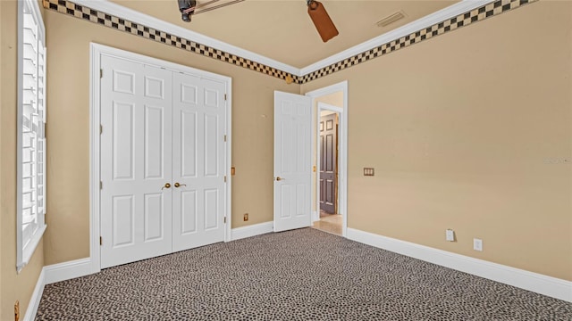 unfurnished bedroom featuring crown molding, a closet, ceiling fan, and carpet