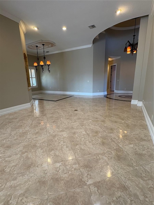 spare room featuring a notable chandelier and crown molding