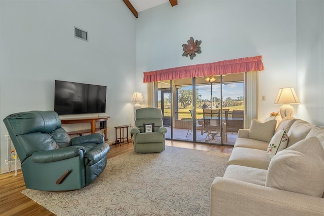 living room featuring beam ceiling, high vaulted ceiling, and hardwood / wood-style flooring