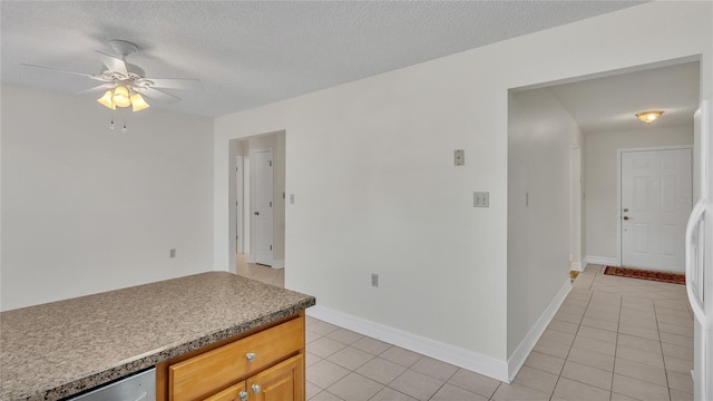 kitchen with ceiling fan, light tile patterned floors, and a textured ceiling