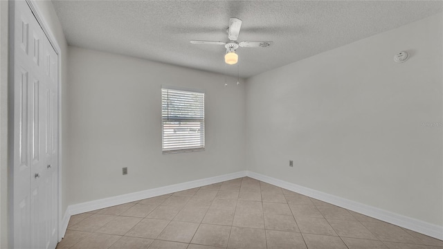 spare room with light tile patterned floors, a textured ceiling, and ceiling fan