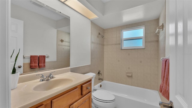 full bathroom with tiled shower / bath combo, toilet, and vanity