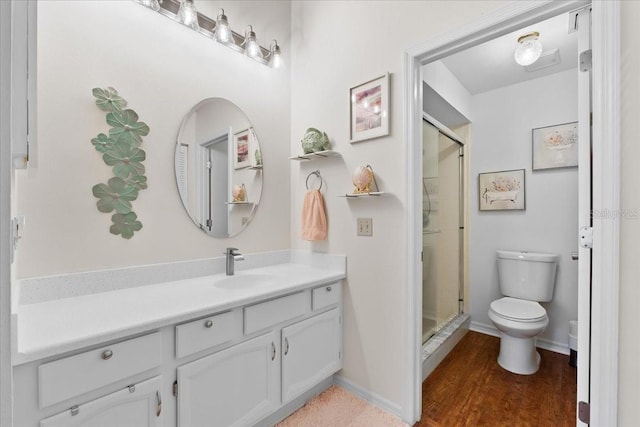 bathroom featuring hardwood / wood-style floors, vanity, toilet, and a shower with shower door