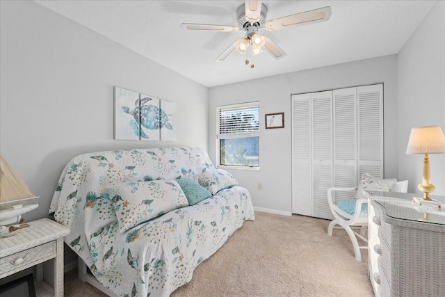 carpeted bedroom featuring ceiling fan and a closet