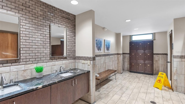 bathroom with vanity and tile walls