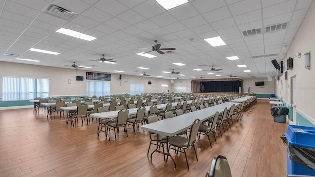 dining space featuring hardwood / wood-style floors, a paneled ceiling, and ceiling fan